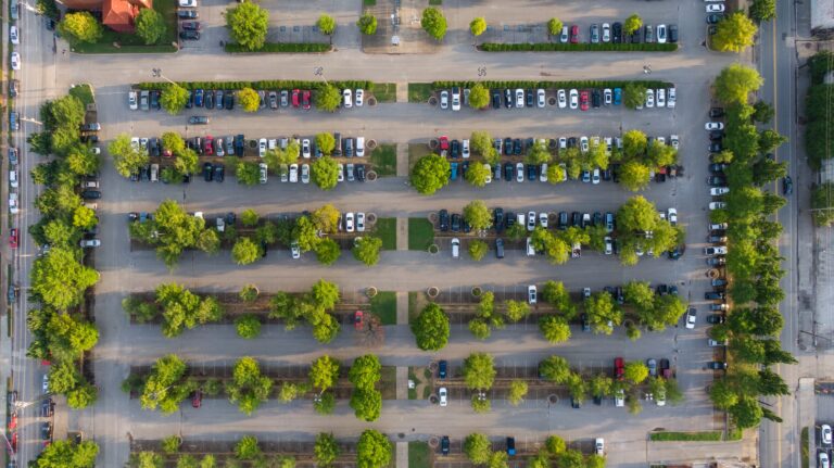 Parkplatz mit Autos und Bäumen von oben